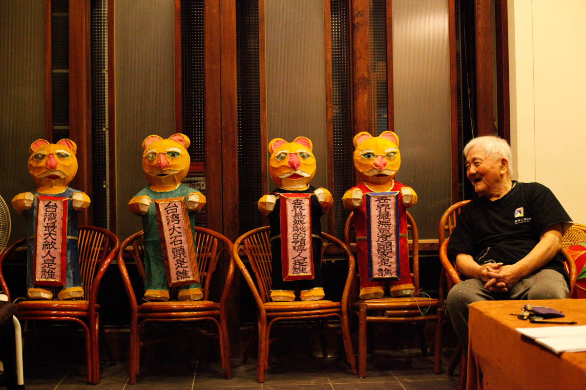 'Lasershows are new for me but they are amazing,' Zai Gan Hsiao said, adding that he will keep making traditional lanterns regardless of his age. He emphasised that 'life has just started'. Hsiao would keep lanterns at home if he was unable to finish them on time. These four tiger lanterns, made eight years ago, were ornamented with witty questions that represent his beliefs, and stand on four chairs in his studio at all times. [Yunjie Liao/Al Jazeera]