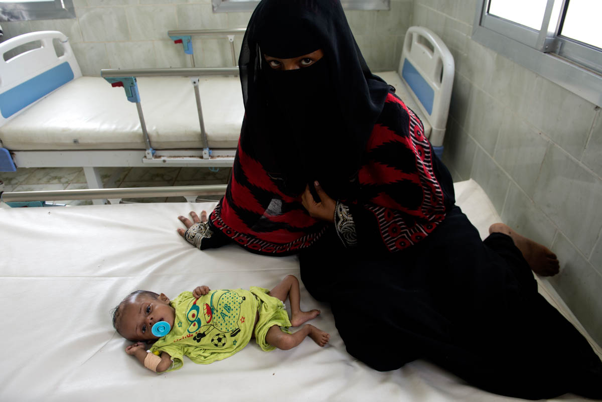 Four-month-old Faisal, seen here with his mother in the Lahj-based hospital, suffers from malnutrition and dysentery. They are from a small rural village where access to food and drinking water is much more difficult than in cities. [Judith Prat/Al Jazeera]