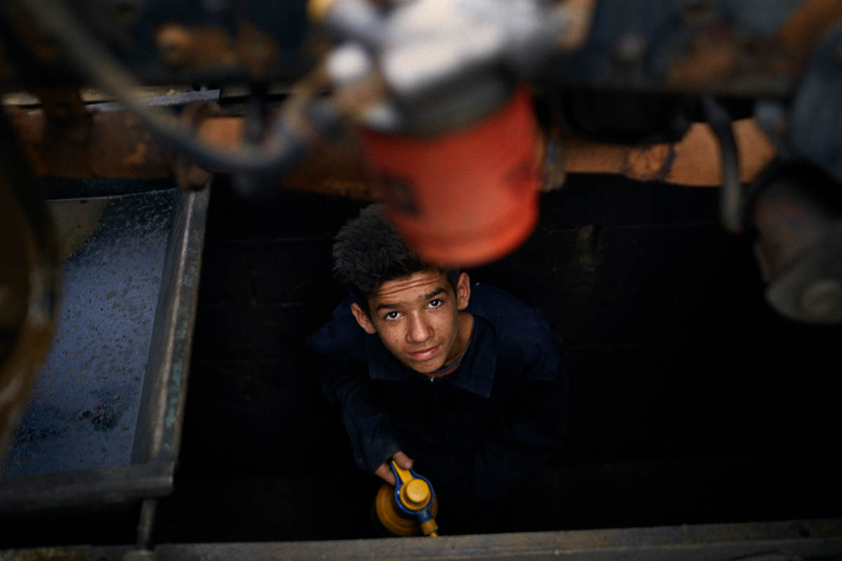 Ahmad, a 15-year-old Syrian refugee, works at his uncle's garage in Bar Elias in the Bekaa Valley. He washes cars in the summer and goes to school in the winter. Limited resources and work restrictions on Syrian parents mean that children are often sent to work, missing out on their education. Syrian refugees often have no choice but to work informally without the correct permits, making them vulnerable to exploitation and the threat of detention and deportation. [Diego Ibarra Sanchez/SaferWorld]