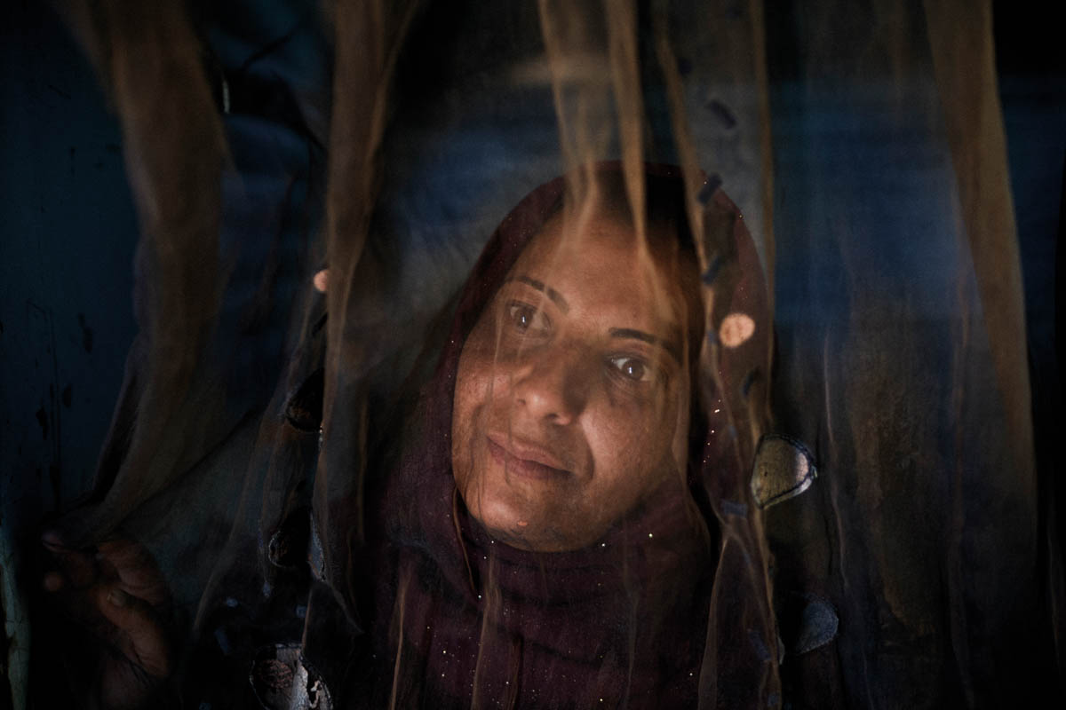 Yusra, 35, looks out of her tent in the Al Fares Syrian refugee settlement in the Bekaa Valley. She left Syria in 2011 with her husband and eight-month-old baby. Yusra has successfully applied for two grants from organisations to help her set up her own business. 'My dream is now to get an administrative job at a larger company. I'm only looking for a better future for my son.' [Diego Ibarra Sanchez/SaferWorld]
