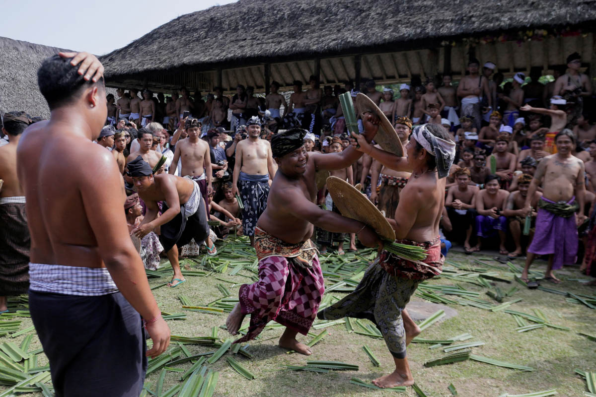 Balinese men fight using thorny pandanus leaves during the annual sacred Mekare-kare ritual, dedicated to the god of war, in Tenganan Village, Bali, Indonesia. [Johannes P Christo/Reuters]