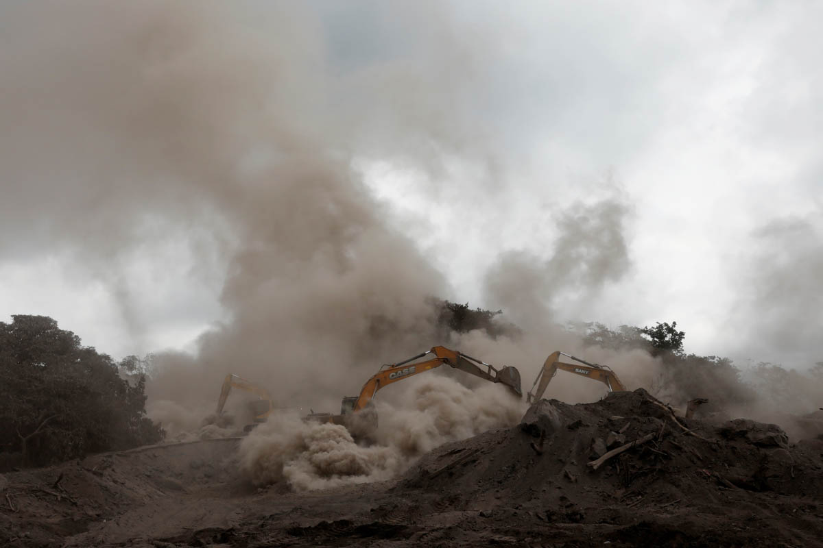 Rescue workers use excavators in an area affected by the eruption of the Fuego volcano. [Carlos Jasso/Reuters]