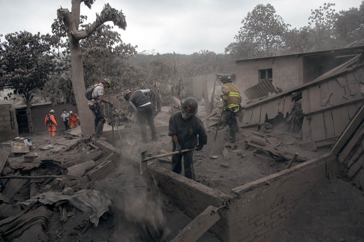 Firefighters work in the disaster zone blanketed in volcanic ash. [Rodrigo Abd/AP Photo]