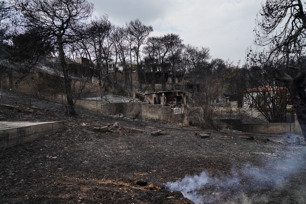 La tierra quemada todavía ardía en algunas partes de Mati cuando los residentes volvían a encontrar restos de sus hogares.  [Nick Paleologos / SOOC / Al Jazeera]
