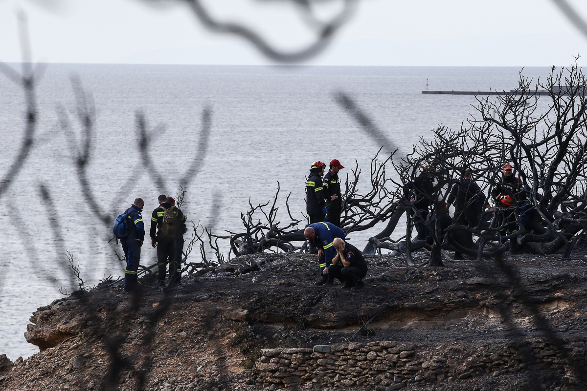 Los cuerpos de 26 personas, entre ellos varios niños, se encontraron acurrucados juntos cerca de un acantilado con vistas al mar.  Los funcionarios creen que el grupo no pudo encontrar una manera de escapar de las llamas.  [Nick Paleologos / SOOC / Al Jazeera]