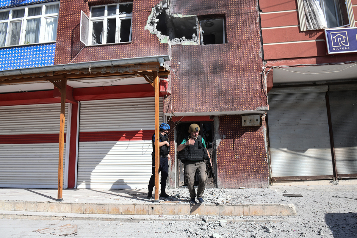 Turkish police officers secure the building in Akcakale that was hit by a mortar reportedly fired from Syria. [Burak Kara/Getty Images]