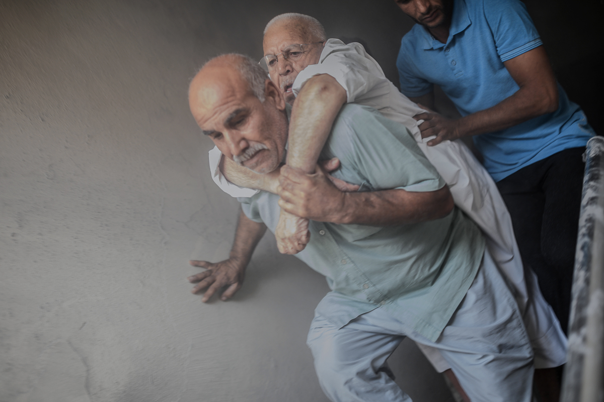 An elderly man is evacuated from a building in Akcakale, a Turkish town near the border with Syria, after it was hit by a mortar reportedly fired from within Syria. [Bulent Kilic/AFP]