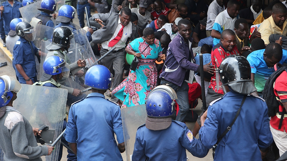 Police surround and  assault opposition party supporters  who had gathered  to hear a speech by the countrys  top  opposition leader in Harare, Wednesday, Nov, 20, 2019. Zimbabwean police  with riot g