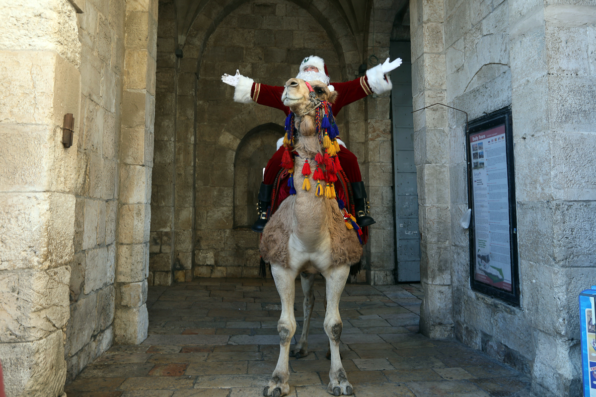 A man dressed as Santa Claus rides a camel through Jerusalem's Old City. [Mahmoud Illean/AP Photo]