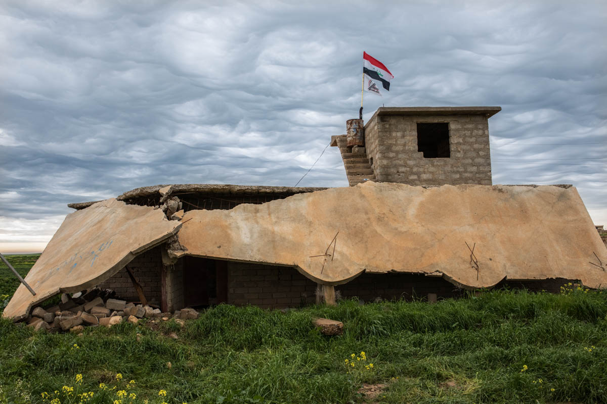 A house in Kojo with an Iraqi flag on the rooftop that was destroyed during the ISIL occupation. [Alessio Mamo/Al Jazeera]