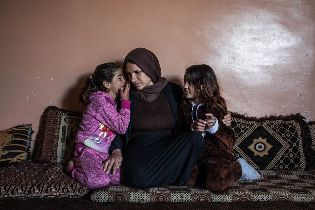 Aisha, with her two daughters, Jinan and Jihan, in their house in Sinjar. While their mother was enslaved by ISIL, she didn't have any news about the two small girls who were also kidnapped by the ISIL fighters. In 2018 they returned from Syria in two different rescue operations and were reunited with their mother. [Alessio Mamo/Al Jazeera]