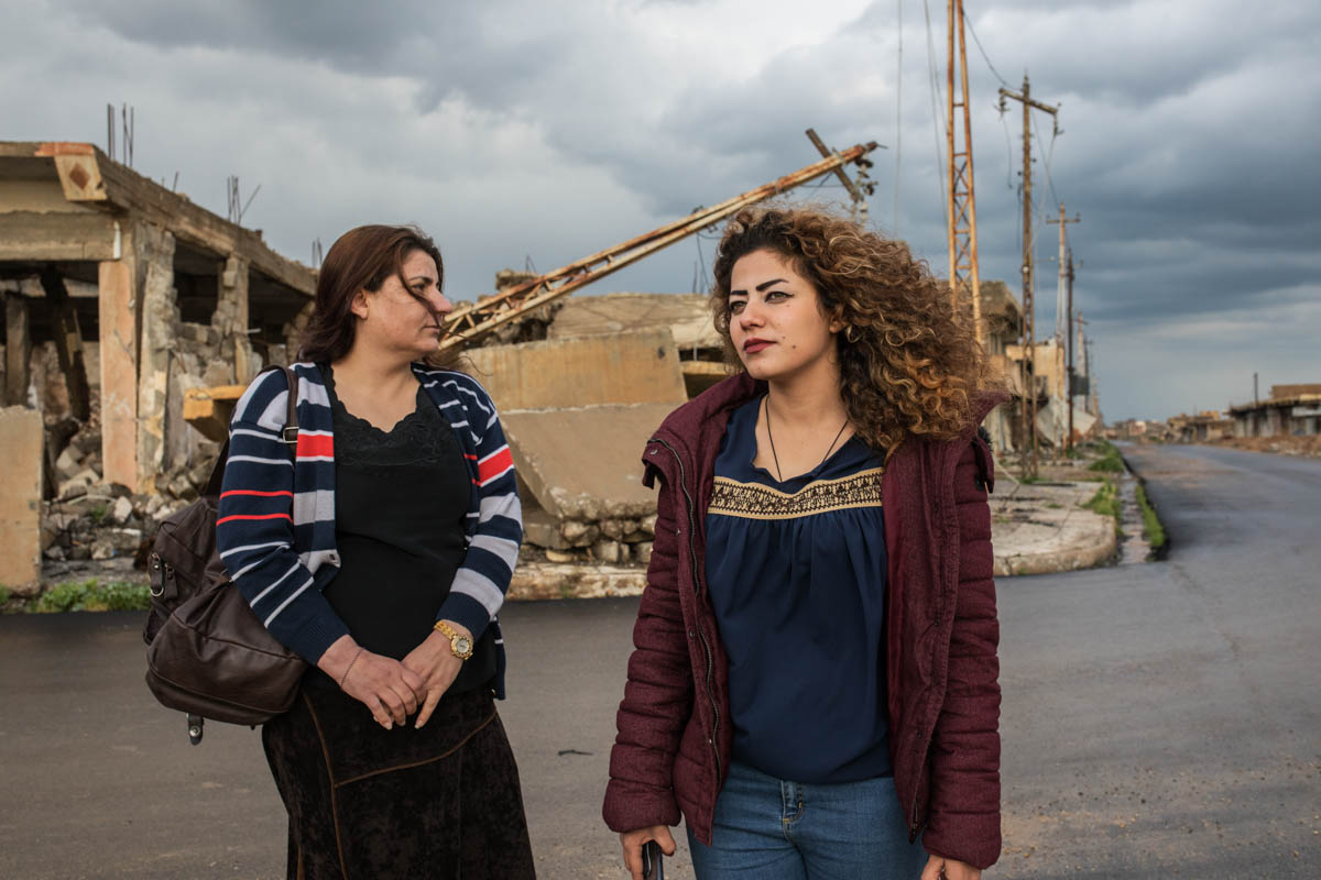 Nada and Shana in the old city of Sinjar where they used to live before the ISIL occupation. The day ISIL arrived, they left their homes and only returned in 2019. [Alessio Mamo/Al Jazeera]
