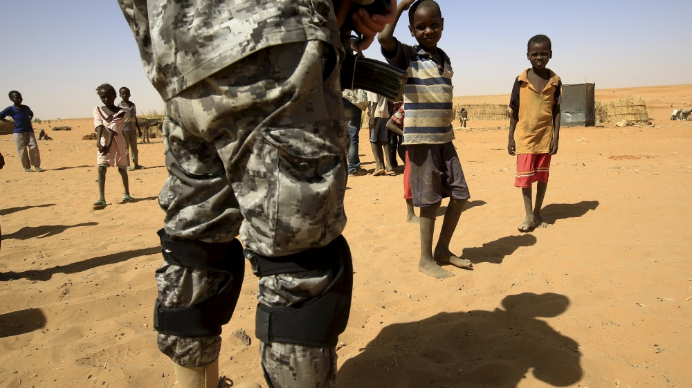 Newly arrived children look towards a UNIMED peacekeeper at the Zam Zam IDP camp, near Al Fashir in North Darfur