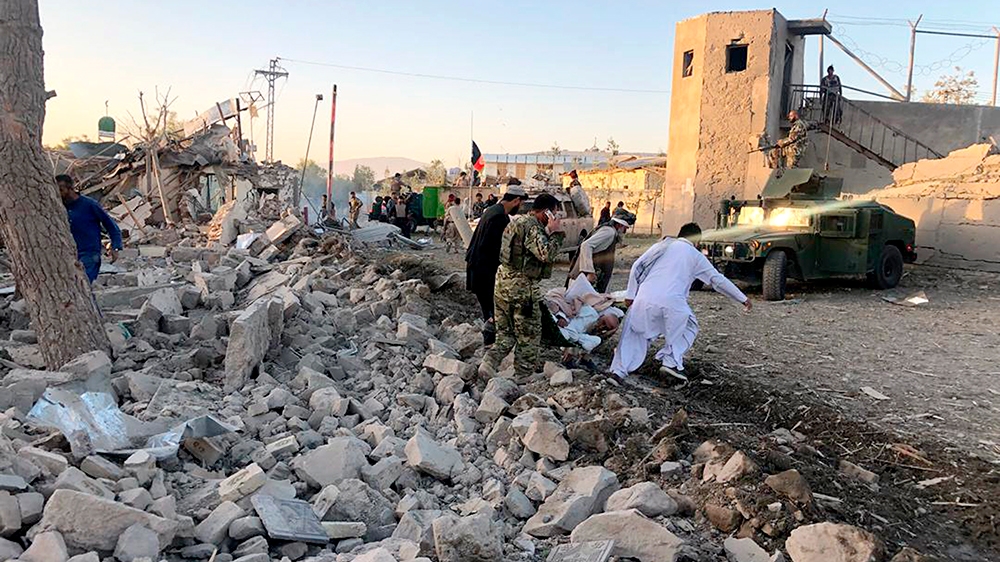 Afghan security members and people work at the site of a suicide attack in Zabul, Afghanistan, Thursday, Sept. 19, 2019. A powerful early morning suicide truck bomb devastated a hospital in southern A