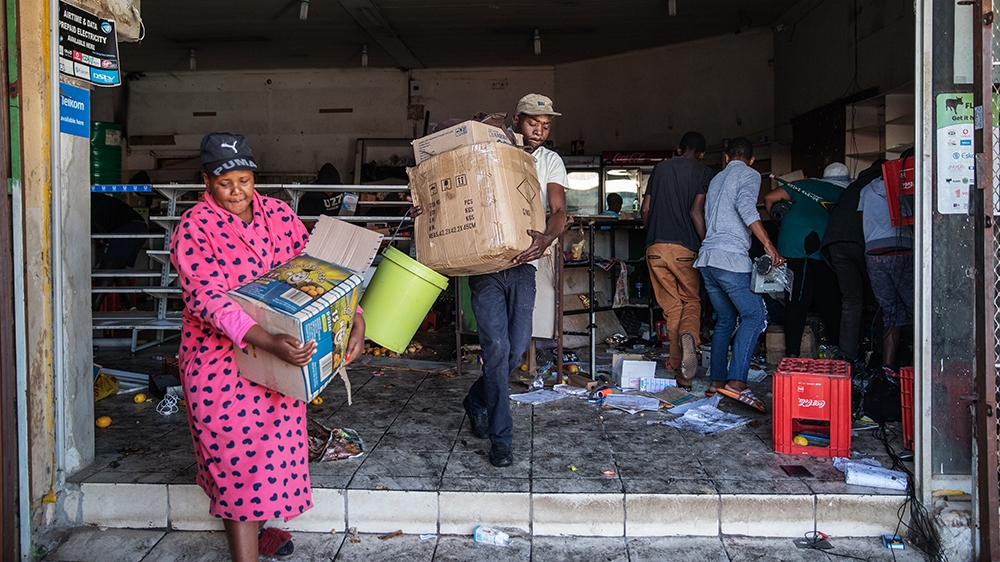 Looters take items from an alleged foreign-owned shops during a riot in the Johannesburg suburb of Turffontein on September 2, 2019 as angry protesters loot alleged foreign-owned shops today in a new 
