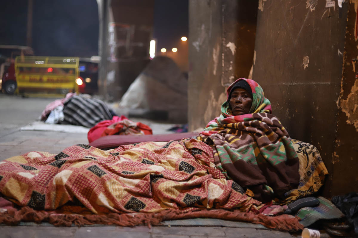 Living under a flyover near the popular Lajpat Nagar market, Noor Bi, 62, had faded memories of her past. She claimed to be from Delhi itself but was not sure how she ended up living on the streets. 'Son, this cold is unbearable. I have never felt so much cold in my entire life. I think I will die here,' she said as she received another blanket from a volunteer. 'I cannot walk properly. Here people give me food and blankets,' she said. [Nasir Kachroo/Al Jazeera]