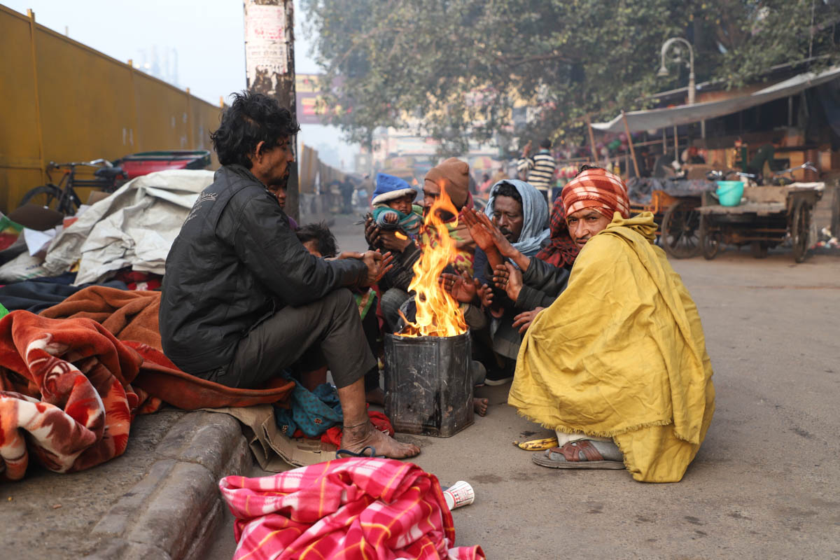 Homeless in New Delhi are often seen collecting rubbish from nearby shops and burning it to keep themselves warm. [Nasir Kachroo/Al Jazeera]