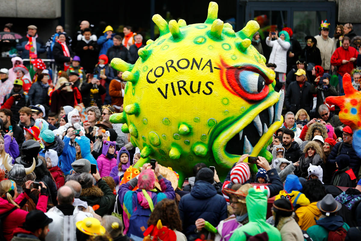 A figure depicting the coronavirus is passed around during the Rosenmontag (Rose Monday) parade in Duesseldorf, Germany. [Thilo Schmuelgen/Reuters]