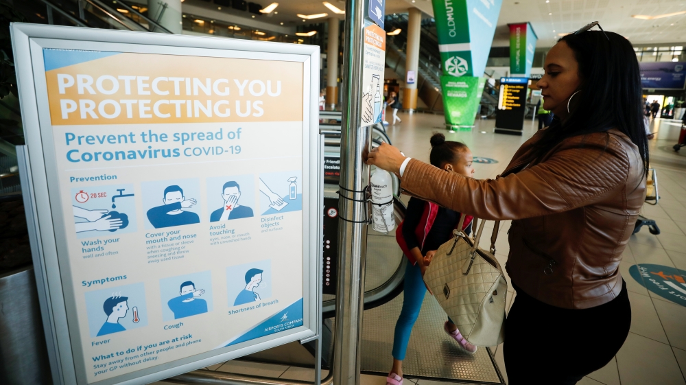 A traveller washes her hands at a sanitizer distribution point intended to slow the spread of the coronavirus disease (COVID-19), at Cape Town International Airport, in Cape Town
