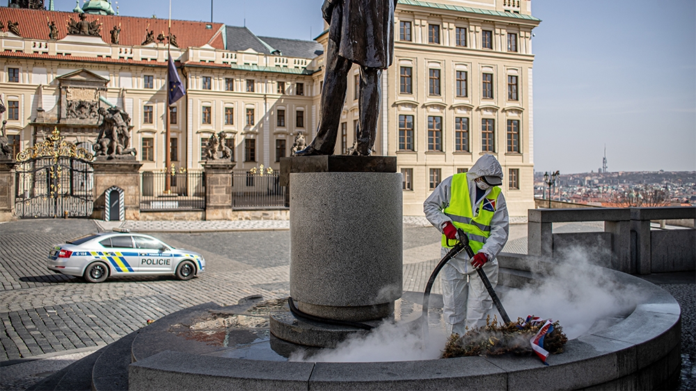 epa08326418 A worker in a protective suit disinfects the statue of first Czechoslovak President T. G. Masaryk at Hradcanske Square in Prague, Czech Republic, 27 March 2020. The Czech government has im