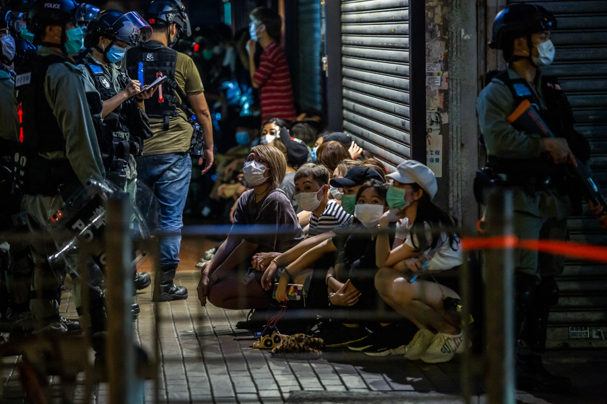 In the evening, clashes spilled onto the streets, with police using batons and pepper spray in the busy commercial neighbourhood of Mong Kok and making more arrests, including of a pro-democracy lawmaker. [Isaac Lawrence/AFP]