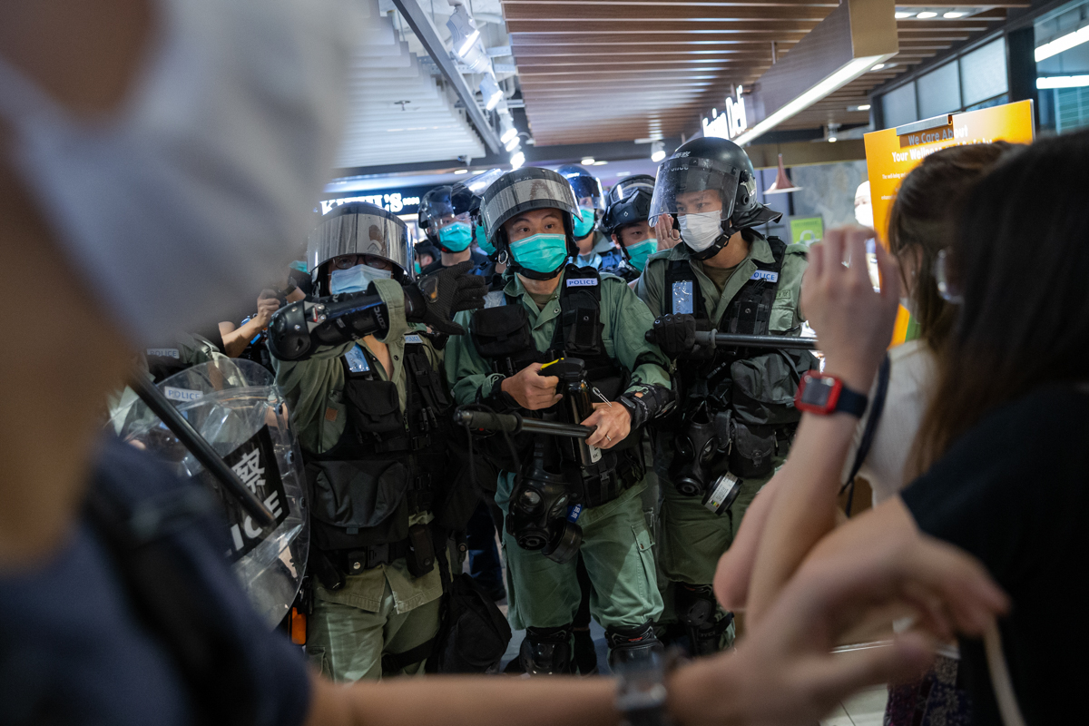 Police officers clear a supermarket of shoppers and suspected protesters as heavy police presence in Tsim Sha Tsui thwarted plans for a pro-independence march. [Jerome Favre/EPA]