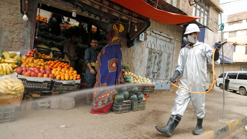 Un trabajador de la salud que usa un traje de protección desinfecta un mercado en medio de la preocupación por la propagación de la enfermedad por coronavirus (COVID-19), en Sanaa