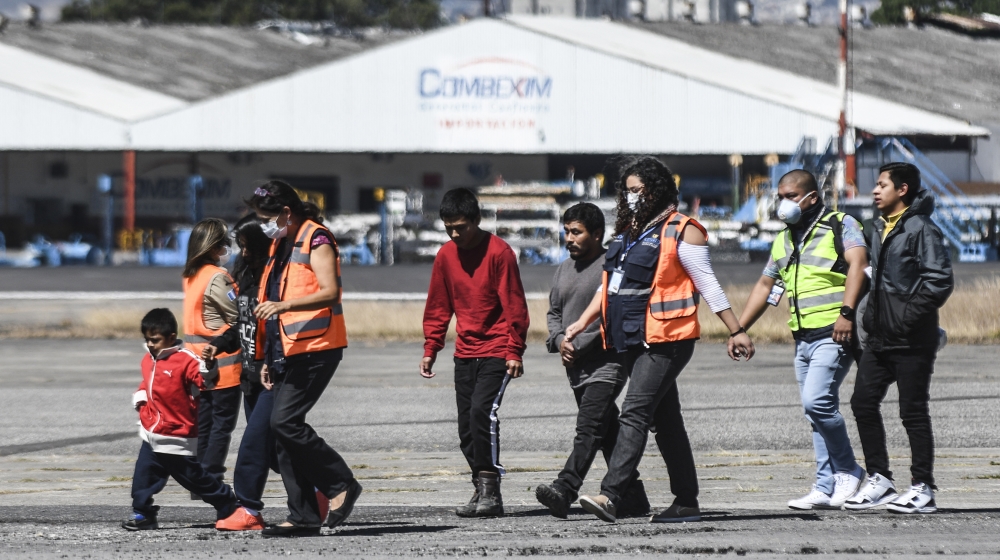 Guatemalan immigration officials use protective equipment as a preventive measure against the new coronavirus, COVID-19, as they receiving Guatemalan migrants deported from the United States, at the A