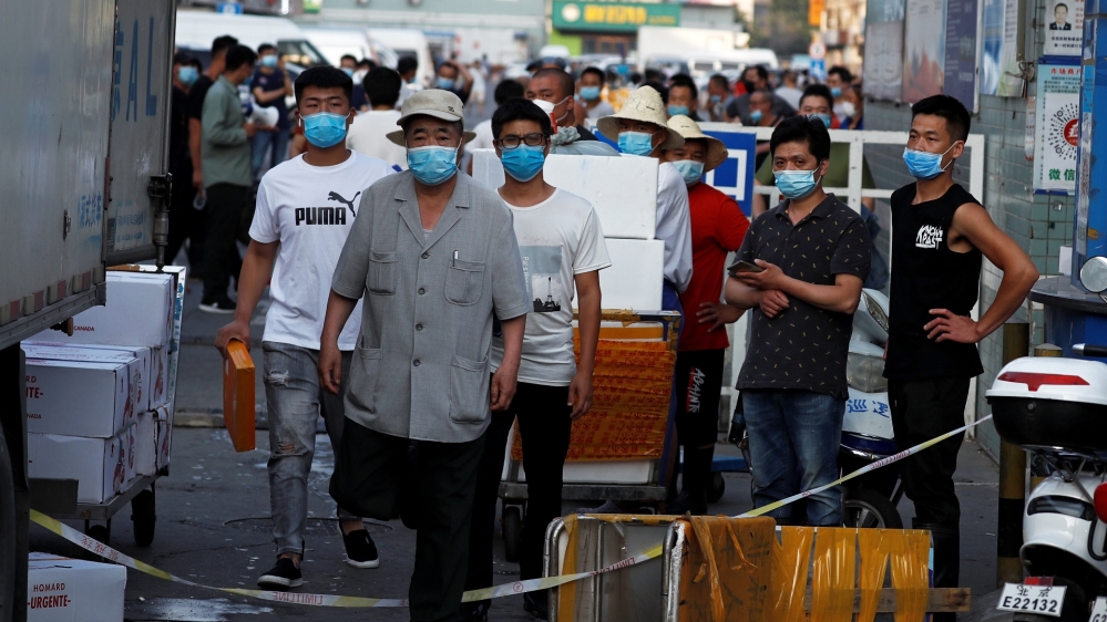 People are wearing face masks inside the Jingshen seafood market which has been closed for business after new coronavirus infections were detected, in Beijing