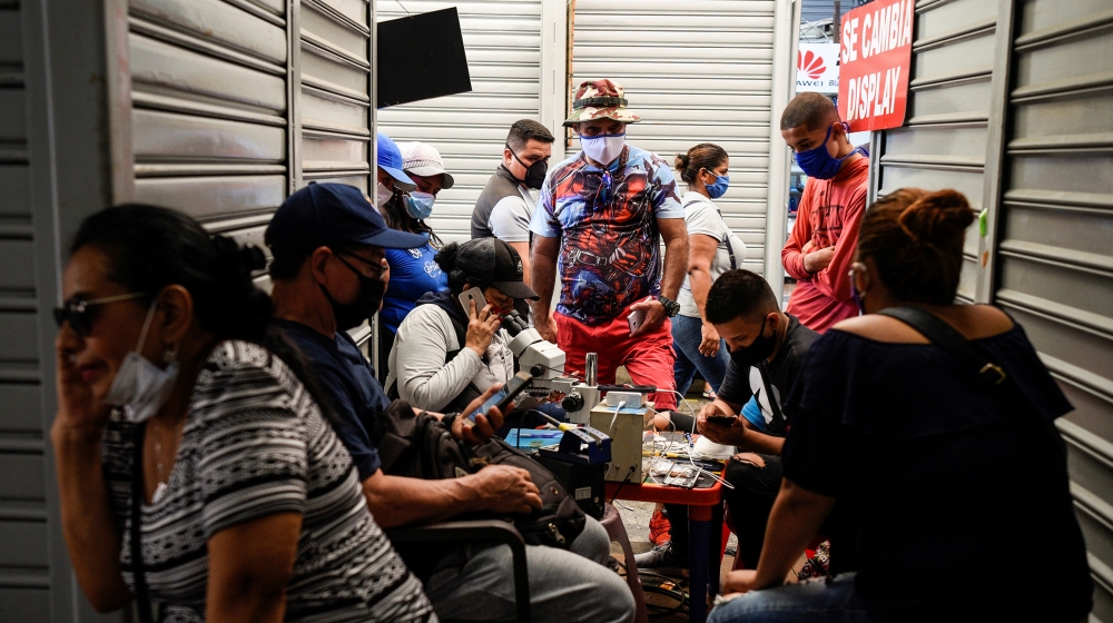 A cell phone repair shop attends customers in a shopping mall as the city allowed some businesses to reopen on Wednesday following a fall in daily deaths due to the outbreak of the coronavirus disease