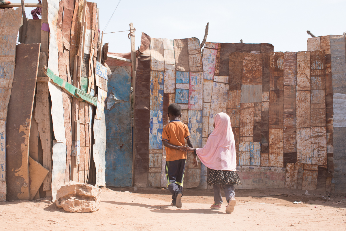 Two Ethiopian children outside their home in a shantytown in Burco, Somaliland. The informal settlement, which has existed for several years, is home to dozens of Ethiopian migrants who tried to make the journey to Saudi Arabia but failed to even reach Yemen. Most wish to return to their villages in Ethiopia but lack the money to do so. [Muse Mohammed/IOM]