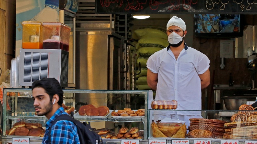 An Iranian man walks in front of a pstry shop in the capital Tehran on June 3, 2020, amid the novel coronavirus pandemic crisis. The spread of novel coronavirus has accele