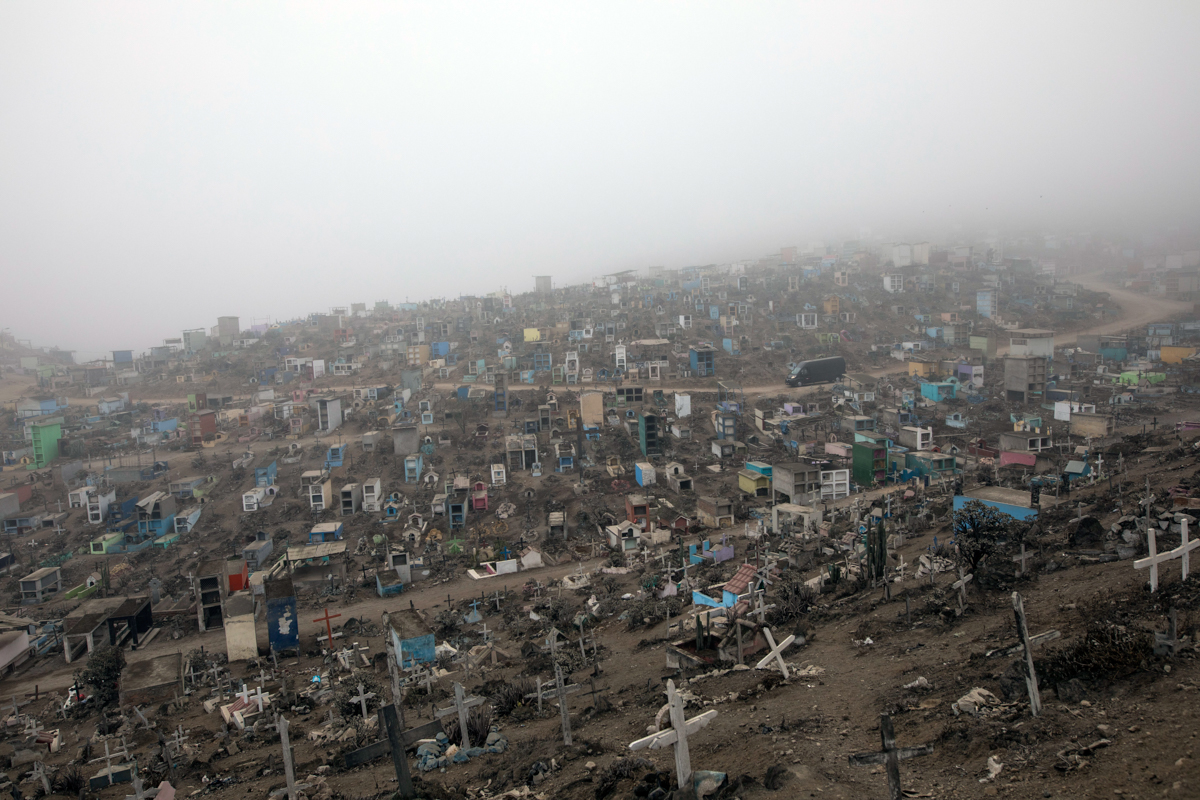 A funeral home vehicle carrying COVID-19 victims drives through the Nueva Esperanza Cemetery on the outskirts of Lima, Peru. [Rodrigo Abd/AP photo]