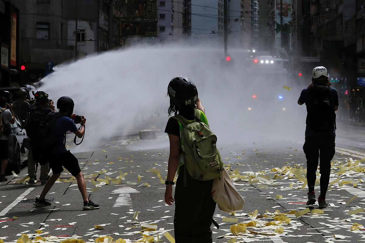 Riot police used water cannons to disperse protesters. [Tyrone Siu/Reuters]