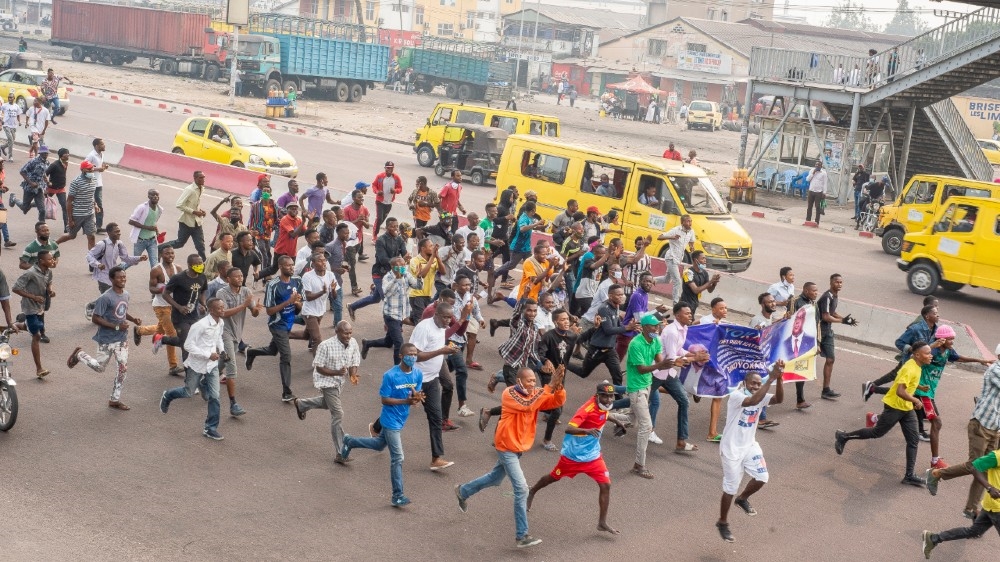 Οι διαδηλωτές τρέχουν στο δρόμο κατά τη διάρκεια διαμαρτυρίας όπου διαδηλωτές και αστυνομικοί συγκρούστηκαν στην Κινσάσα στις 9 Ιουλίου 2020 σε διαδηλώσεις που οργανώθηκαν κατά της 