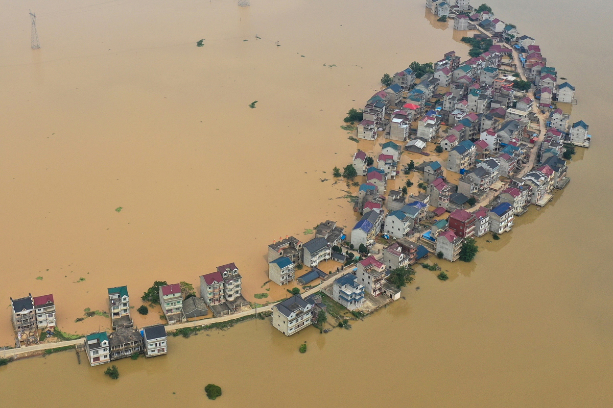 Submerged streets and inundated buildings after a dam was breached due to flooding in Jiujiang in China's central Jiangxi province. [AFP]