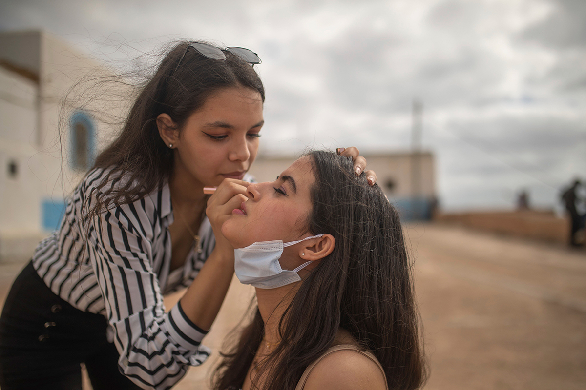 Yasmin, left, and her friend, Mariam, right, are spending time outdoors for the first time since lockdown measures were imposed. [Mosa'ab Elshamy/AP Photo]