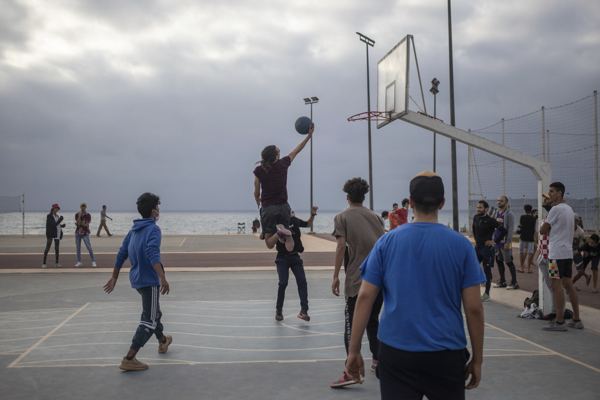 Teenagers playing basketball in a reopened court in Rabat. [Mosa'ab Elshamy/AP Photo]