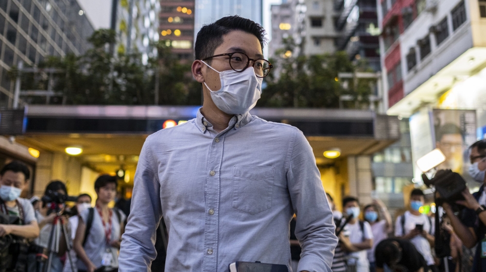 Nathan Law, standing committee member of the Demosisto political party, wears a protective face mask as he arrives for a news conference to announce his bid to enter into the unofficial pro-democratic