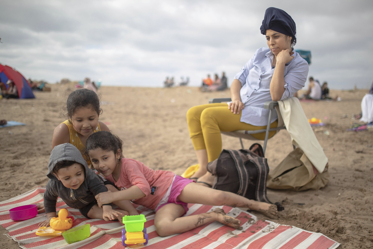A family enjoying outdoor time at a reopened beach in Sale. [Mosa'ab Elshamy/AP Photo]