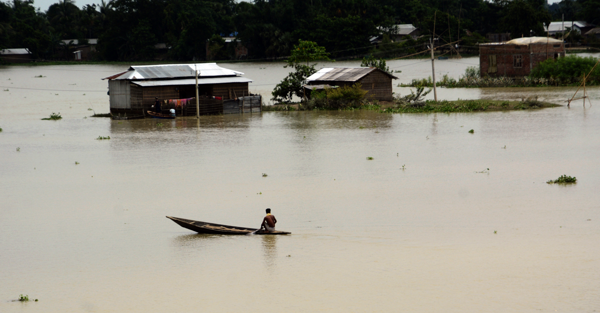 Një njeri rresht varkën e tij pranë shtëpive pjesërisht të zhytura në rrethin Morigaon të Asam.  Sipas njoftimeve të lajmeve, shteti Assam vazhdon të luftojë me përmbytjet që kanë lënë më shumë se tre milion njerëz të zhvendosur dhe të paktën 60 të vdekur.  [EPA]