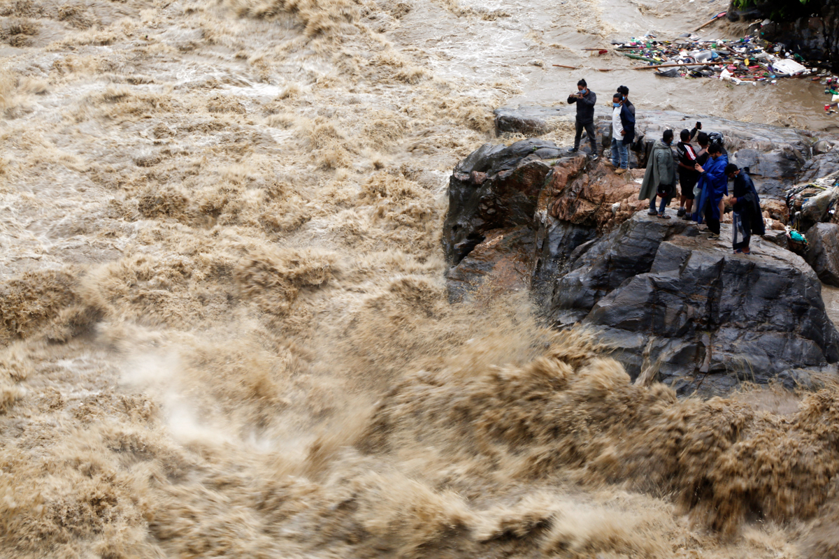 Njerëzit Nepalese në brigjet e lumit Bagmati të përmbytur në Kathmandu.  Të paktën 84 njerëz kanë vdekur në kombin e Himayalan ndërsa rrëshqitje të shumta të rrëshqitjeve të tokës shkatërruan rrethet e saj kodrinore ndërsa reshjet e vazhdueshme përmbytën pjesë të përmbytura të fushave jugore.  [Niranjan Shrestha / Fotografia e AP]