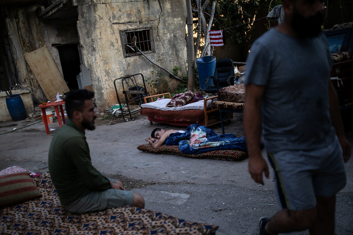 A boy whose home was damaged by the explosion sleeps outdoors on a mattress on the ground in Karantina. [Alkis Konstantinidis/Reuters]
