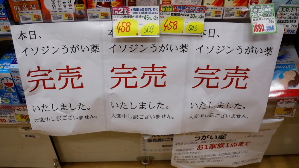 Banners notifying sold-out of gargling medicine are displayed at empty shelves at a drugstore in Tokyo