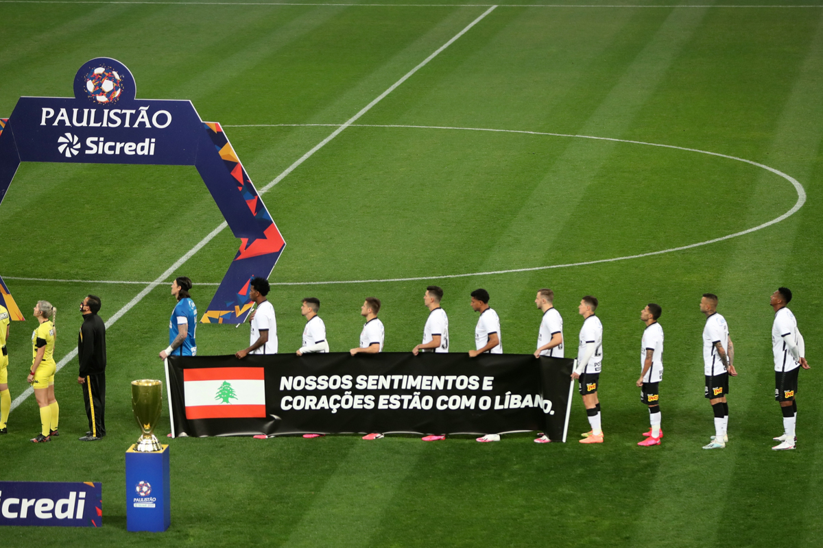 Players from the Brazilian team Corinthians hold a banner honouring victims of the Beirut explosion before the Campeonato Paulista first leg match between them and Palmeiras at Itaquera stadium in Sao Paulo, Brazil. [Fernando Bizerra/EPA]