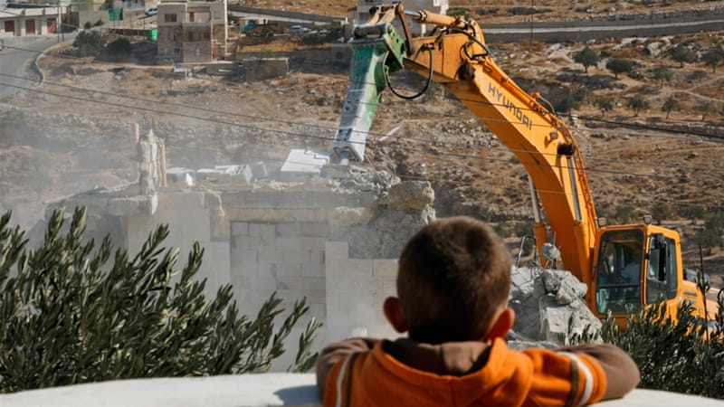 A Palestinian boy looks on as municipality workers demolish a house in the East Jerusalem neighbourhood of Tzur Baher, Tuesday, October 27, 2009. (AP Photo/Dan Balilty)