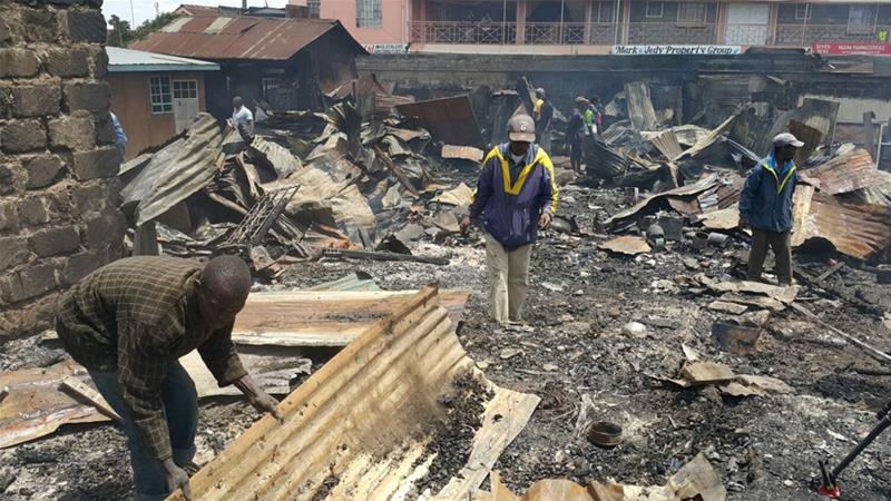 Traders sift through the destruction in Nairobi's Kawangware neighbourhood on Saturday [Hamza Mohamed/Al Jazeera] 