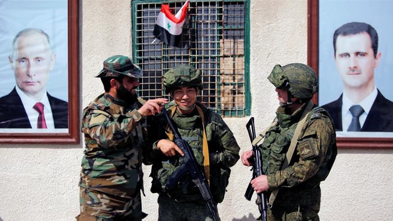 Soldados sirios y rusos se paran en un puesto de control cerca del campamento de Wafideen en Damasco el 2 de marzo de 2018 [Reuters / Omar Sanadiki]
