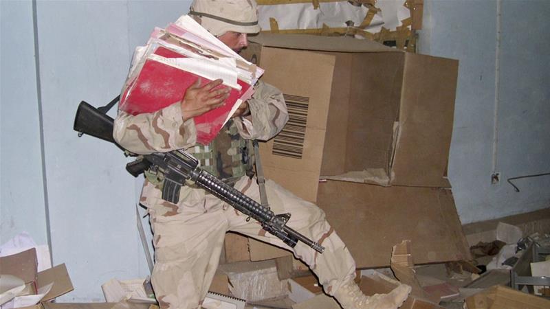 A US soldier hauls documents during a raid conducted at a community centre in Baghdad in June 2003 [AP/Jim Krane]