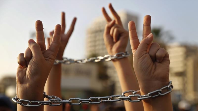 Palestinian boys raise up their hands with chains, during a protest to show their solidarity with hunger striking Palestinian prisoners in Israeli jails, May 4, 2017 [File: Hussein Malla/AP)